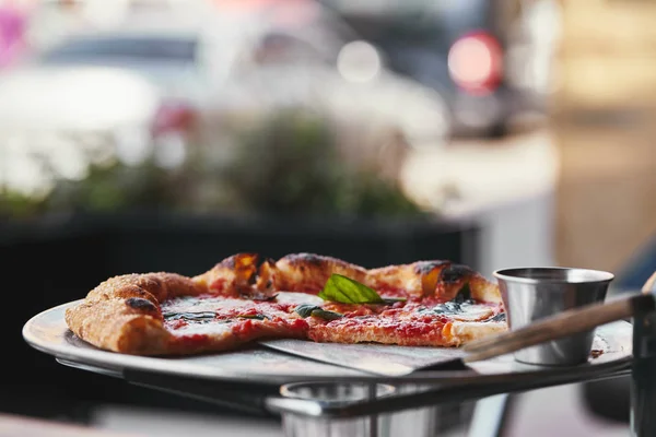 Primer plano de deliciosa pizza en bandeja y sobre fondo borroso - foto de stock