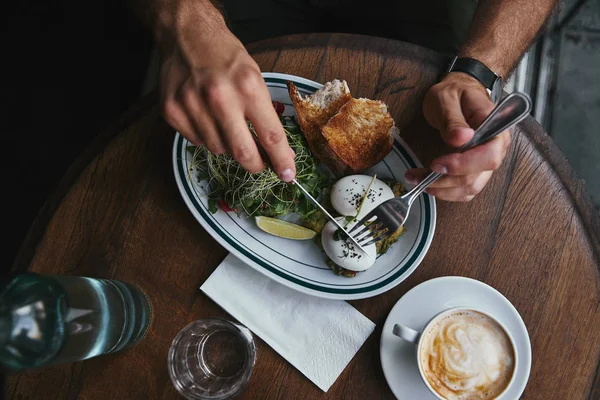 Colpo ritagliato di uomo che cena al ristorante con deliziosa insalata e caffè — Foto stock