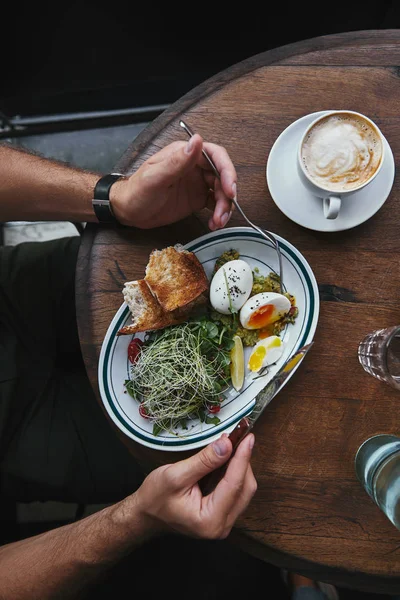 Tiro cortado de homem comendo salada saudável com brotos e ovos — Fotografia de Stock