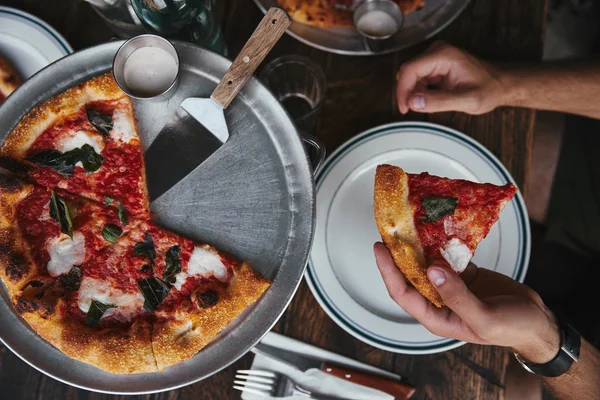 Cortado tiro de homem comendo pizza recém-assada margherita no restaurante — Fotografia de Stock