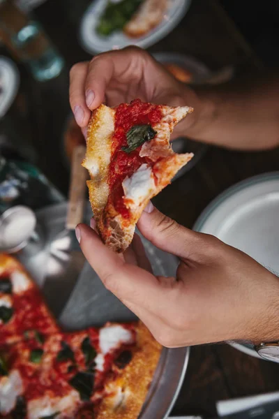 Plan recadré de l'homme mangeant une délicieuse pizza au restaurant — Photo de stock