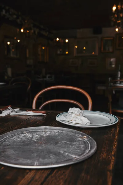 Bandeja de cocina de metal vacía con plato blanco en la mesa de madera en el restaurante - foto de stock
