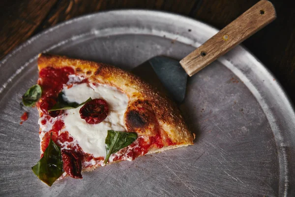 Top view of delicious pizza with server on metal tray and wooden table — Stock Photo