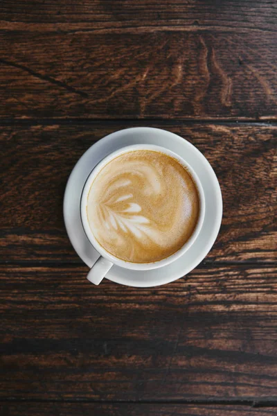 Draufsicht auf Tasse leckeren Kaffee auf rustikalem Holztisch — Stockfoto