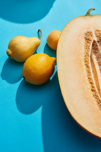 Close-up view of fresh ripe melon, pear, apricot and lemon on blue — Stock Photo