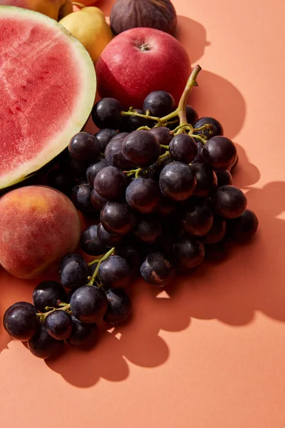 Vista dall'alto di uva dolce matura fresca, pesca, mela e anguria su rosso — Foto stock