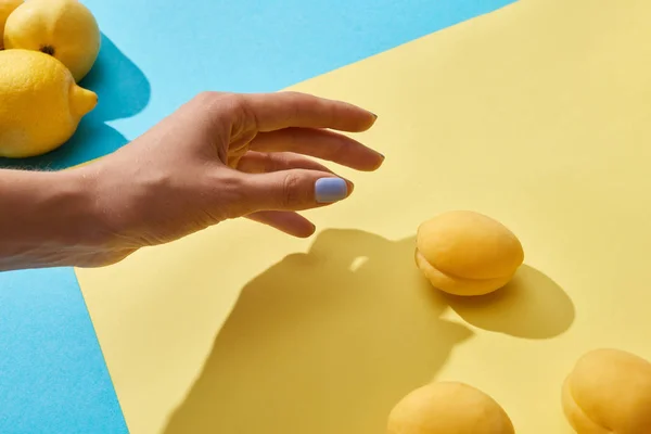 Cropped shot of female hand and fresh ripe sweet apricots — Stock Photo