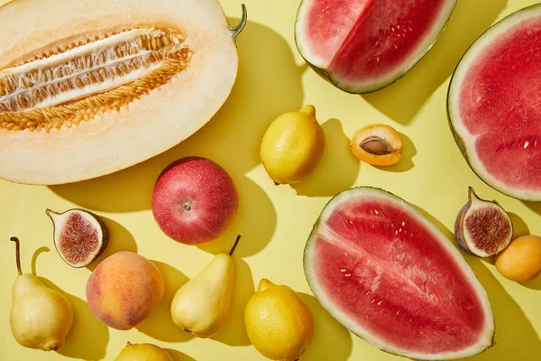 Vue de dessus de melon doux frais mûr, pastèque, citrons, pomme, figue, poire, pêche et abricots sur jaune — Photo de stock