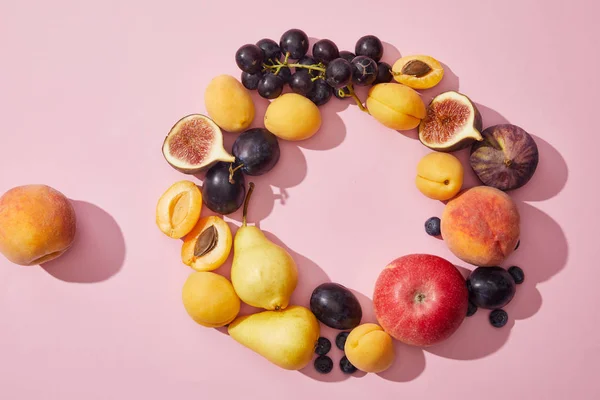 Draufsicht auf frische reife süße leckere Früchte auf violettem Hintergrund — Stockfoto
