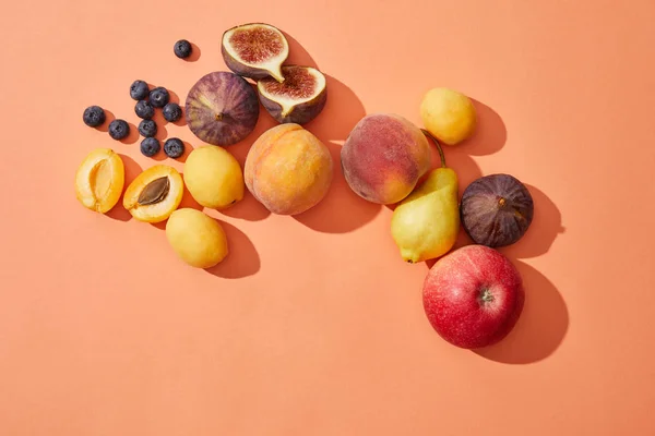 Vista superior de frutas frescas maduras doces e saborosas no fundo vermelho — Fotografia de Stock