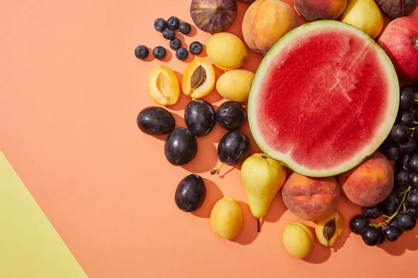 Vista superior de várias frutas frescas maduras doces no fundo vermelho — Fotografia de Stock