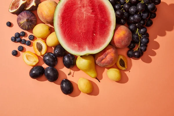 Vista superior de várias frutas frescas maduras e doces de verão no vermelho — Fotografia de Stock