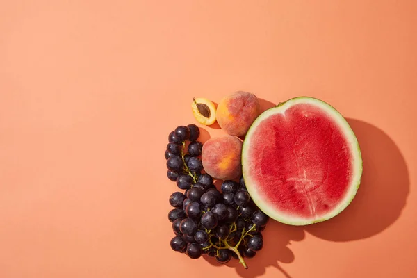 Vista dall'alto di vari frutti freschi maturi dolci su sfondo rosso — Foto stock