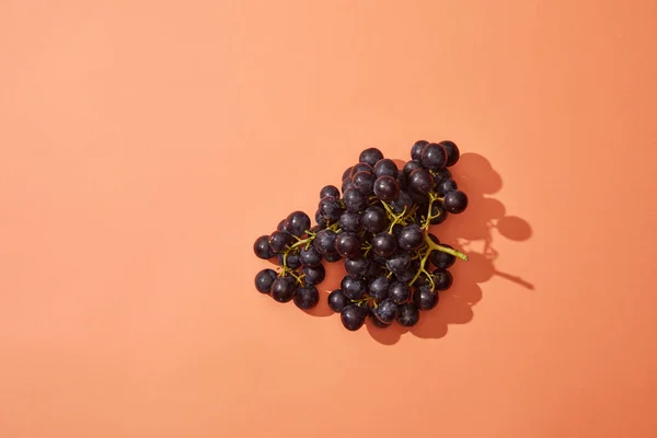 Monte de uvas frescas maduras doces no fundo vermelho — Fotografia de Stock