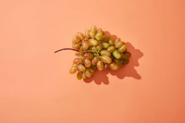 Vue du dessus du bouquet de raisins frais et sucrés sur fond rouge — Photo de stock