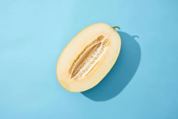 Draufsicht auf die Hälfte der frischen reifen süßen Melone auf blauem Hintergrund — Stockfoto