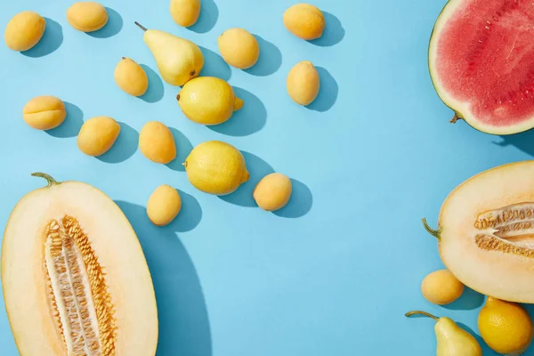 Верхний вид свежих спелых сладких летних фруктов на голубом фоне — стоковое фото