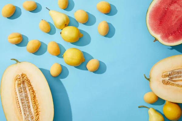 Vista superior de frutas frescas maduras de verano sobre fondo azul - foto de stock