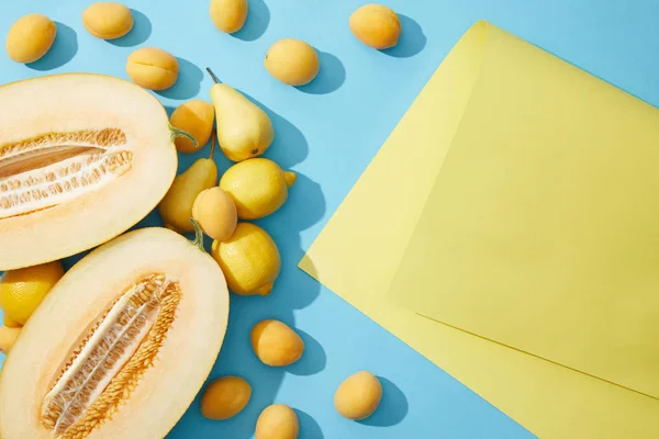 Draufsicht auf leckere reife frische Früchte auf blauem und gelbem Hintergrund — Stockfoto