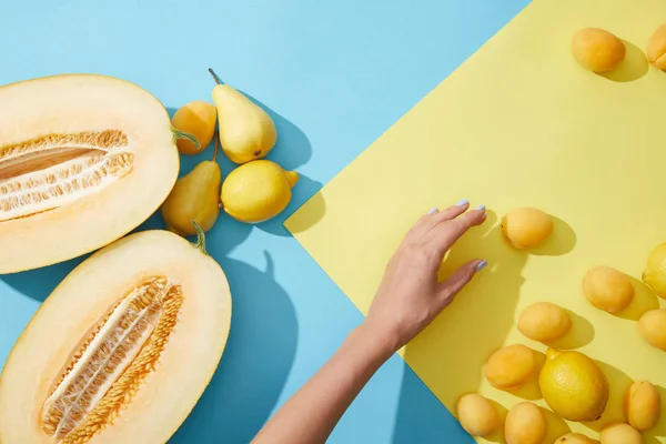 Tiro recortado de mano femenina y frutas amarillas frescas maduras - foto de stock