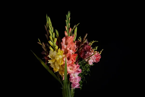 Bouquet of beautiful pink, red, yellow and purple gladioli flowers isolated on black background — Stock Photo