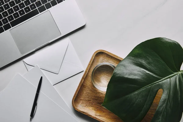 Flat lay template with envelope and laptop on white marble background — Stock Photo