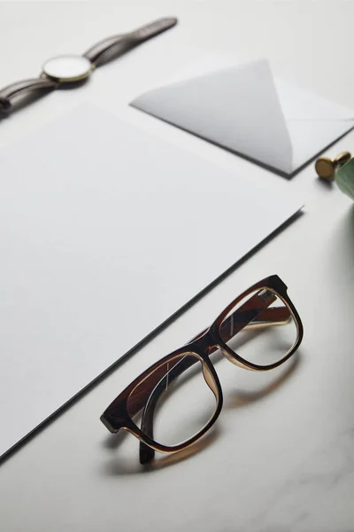 Composition with envelope and glasses on white marble background — Stock Photo