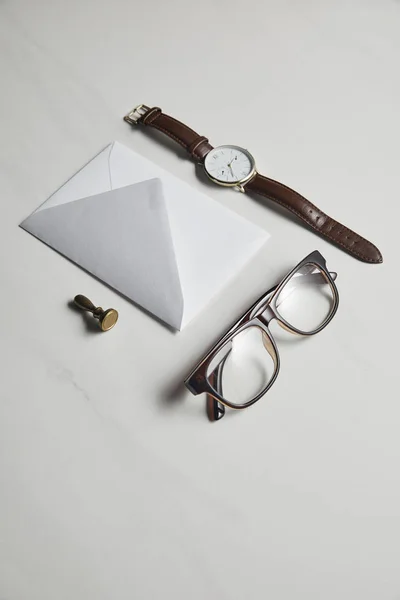 Шаблон канцелярских принадлежностей с часами и очками на фоне белого мрамора — стоковое фото