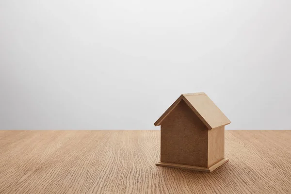 Vista de cerca del modelo de casa pequeña en la mesa de madera en gris, concepto de seguro - foto de stock