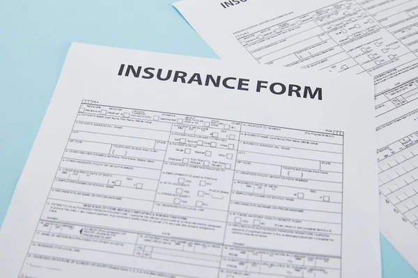 Vista de cerca del formulario de seguro en azul, concepto de seguro - foto de stock