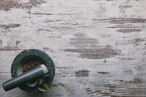 Argamassa e pilão com pimenta na mesa de madeira rústica — Fotografia de Stock