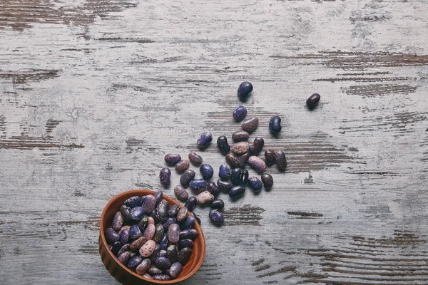 Haricots secs dans un bol sur une table en bois rustique — Photo de stock