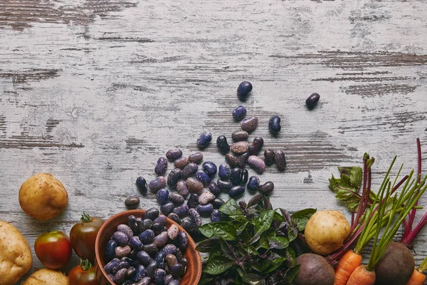 Fagioli fagiolo bianco viola e verdure crude per cucinare su tavolo di legno rustico — Foto stock