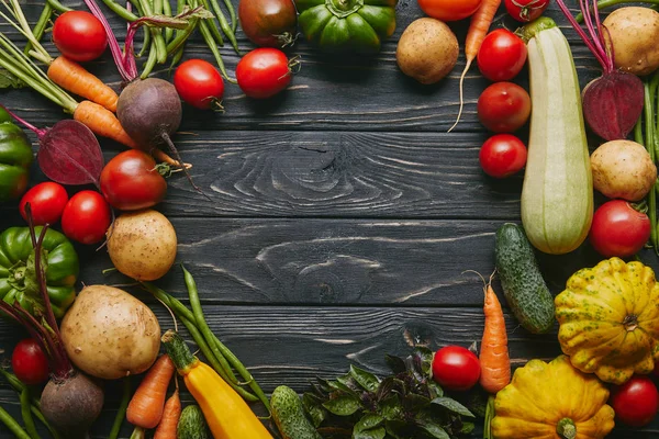 Frame of healthy summer vegetables on dark wooden table — Stock Photo