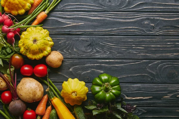Organic raw vegetables on dark wooden table — Stock Photo