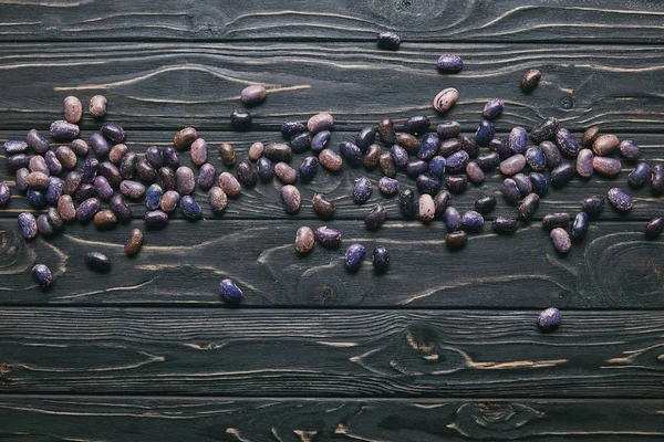 Feijão de feijão roxo na mesa de madeira escura — Fotografia de Stock