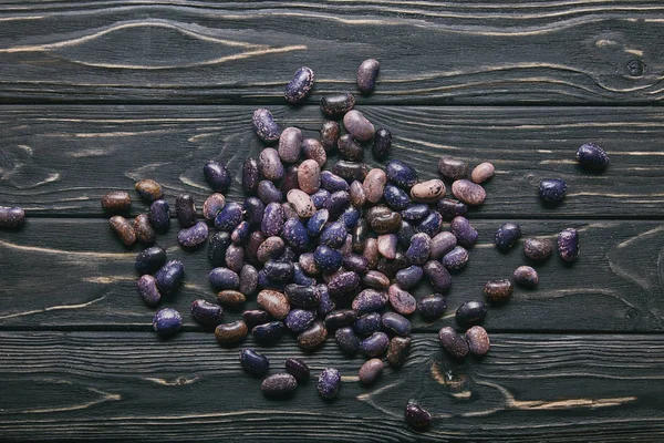 Trockene große Haricot-Bohnen auf dunklem Holztisch — Stockfoto