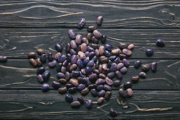 Dry large haricot beans on dark wooden table — Stock Photo