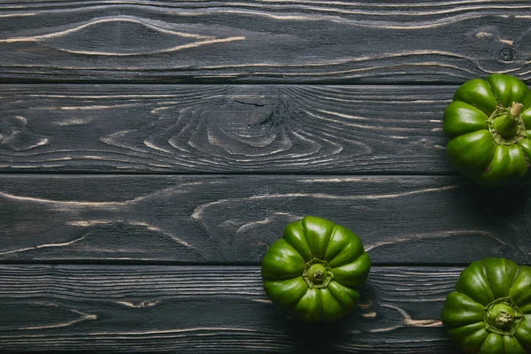 Green bell peppers on dark wooden table — Stock Photo