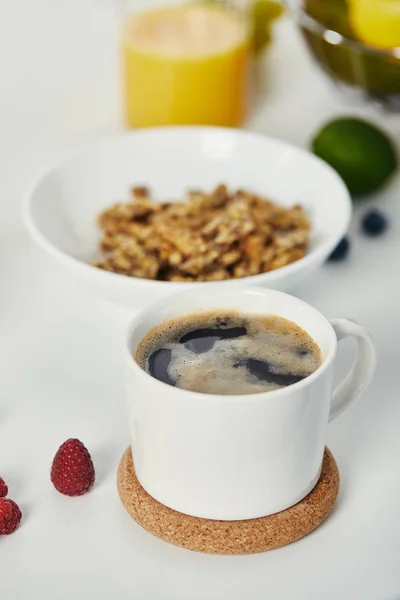 Vue rapprochée de tasse de café aromatique et petit déjeuner sain sur la surface blanche — Photo de stock