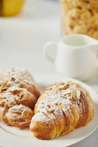Vue rapprochée des croissants sucrés avec de la poudre de sucre pour le petit déjeuner sur table blanche — Photo de stock