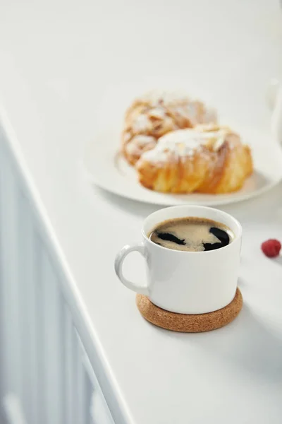 Vista de perto da xícara de café aromático e croissants para o café da manhã na superfície branca — Fotografia de Stock