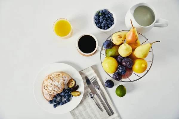 Vista superior de croissant, xícara de café e copo de suco para café da manhã na superfície branca — Fotografia de Stock