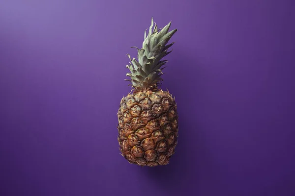Top view of pineapple on violet surface — Stock Photo