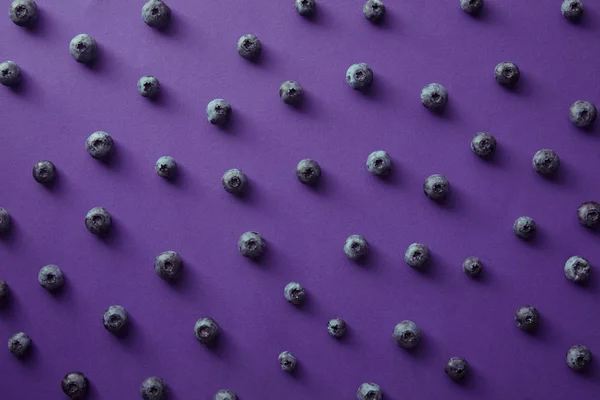 Patrón de arándanos maduros en la superficie violeta - foto de stock