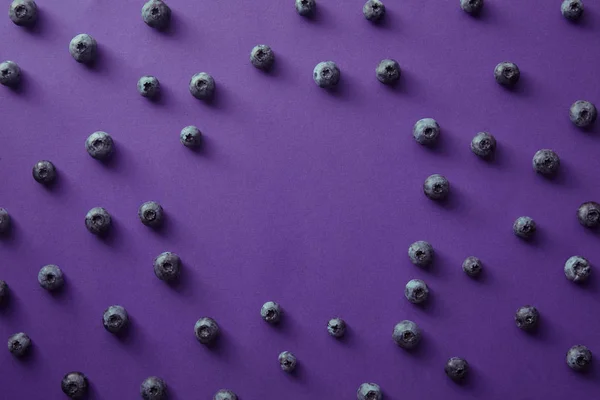 Vista superior del círculo de arándanos en la superficie violeta - foto de stock