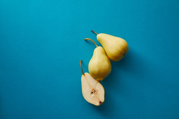 Top view of ripe pears on blue surface — Stock Photo