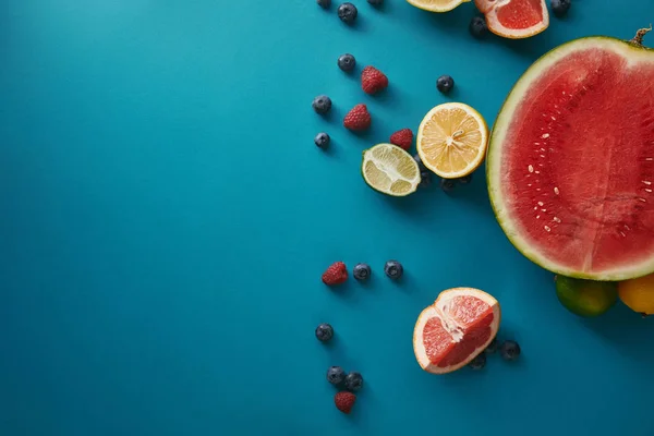 Draufsicht auf Früchte und Beeren auf blauer Oberfläche — Stockfoto