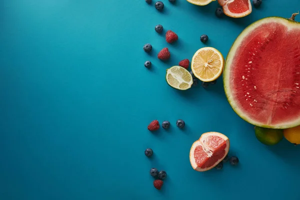 Vista superior de frutas y bayas en la superficie azul - foto de stock