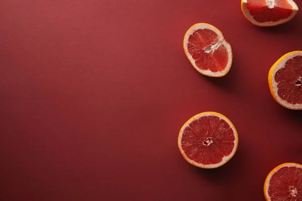 Top view of cut grapefruits on red surface — Stock Photo